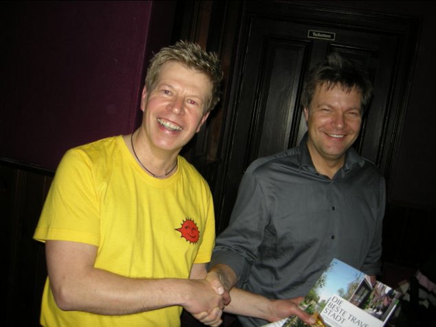 Organisator Manfred Schwartz von "Bad Oldesloe macht Theater" überreicht Robert Habeck die Oldesloer Informationsbroschüre als Dankeschön